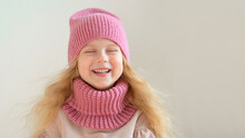 Portrait Of Happy  Little Girl Wearing Knitted Hat And Scarf