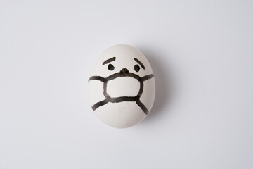 An egg with a face in a mask, on a white background. Quarantine concept covid 19