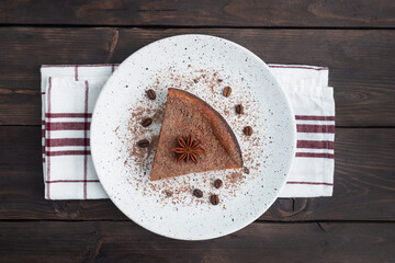 Wall Mural - Slice of chocolate curd casserole on a plate, a portion piece of cake with chocolate and coffee. Dark wooden rustic background. top view copy space