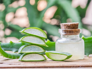 Wall Mural - Fresh aloe leaves and aloe gel in the cosmetic jar on wooden table.