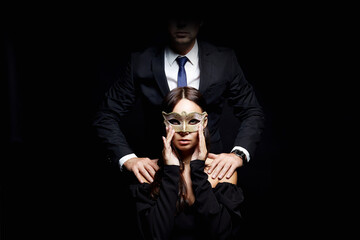 Wall Mural - beautiful woman in mask in the hands of man in a suit