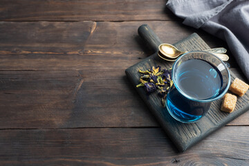 Thai blue tea anchan of buds klitoria Ternate in a glass cup, dark background. Copy space