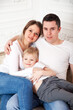 © DariaTrofimova - Family in white and jeans on   light sofa