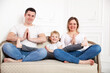 © DariaTrofimova - Happy family with   young son in   yoga pose on   sofa