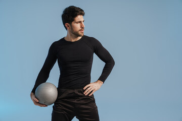 Wall Mural - Handsome athletic sportsman posing with medicine ball