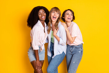 Sticker - Portrait of three attractive impressed amazed cheerful girls having fun embracing good news isolated over bright yellow color background