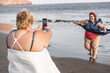 © DisobeyArt - Plus size women friends having fun taking photos on the beach - Focus on right woman face