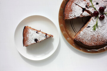 Pice of freshly baked cherry cake on white table background. Overhead view of homemade berry pie.