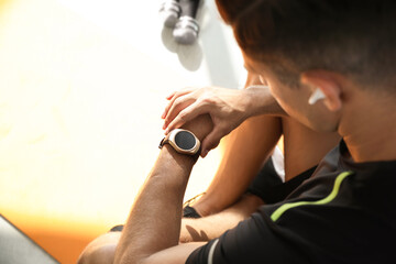 Wall Mural - Man checking fitness tracker in gym, closeup