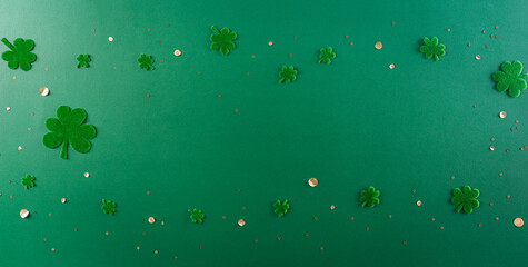 Wall Mural - Happy St. Patricks Day decoration concept. Flat lay, top view of clover leaves on green background with space for text.