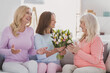 © deagreez - Photo of cheerful happy family woman generation sit couch present flowers holiday indoors inside house