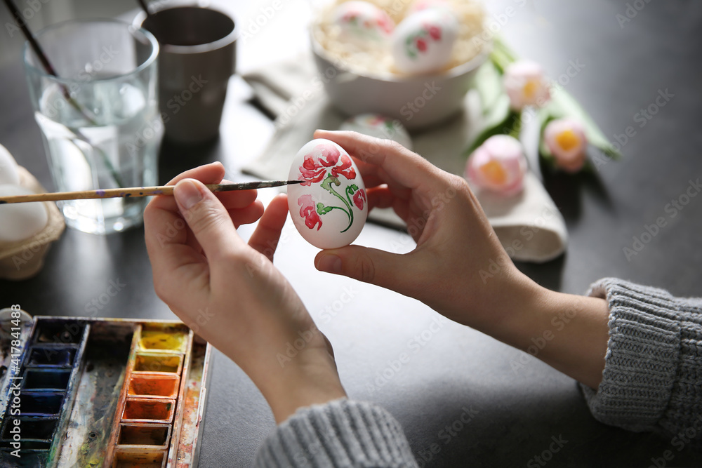 Woman painting Easter egg at black table, closeup - obrazy, fototapety, plakaty 