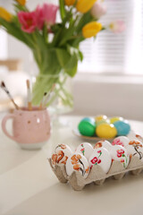 Wall Mural - Beautifully painted Easter eggs on white table indoors, space for text