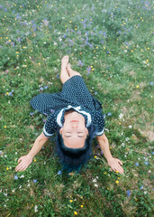 Sticker - Beautiful happy young woman wearing in dress and hat resting on wildflower summer meadow.