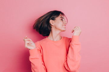 Funny young woman 20s in casual clothes isolated on pink background studio portrait. People emotions lifestyle concept. Mock up copy space. Shaking head with flowing hair