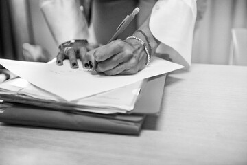 Hand of a woman signing documents in the office