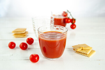 two glass with tomato juice, cherry tomatoes, pieces of Ligurian focaccia