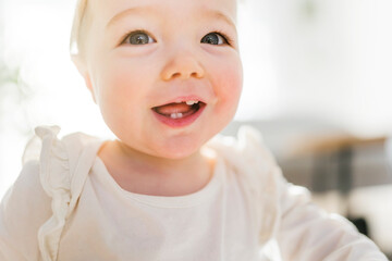 close Portrait of a baby girl having fun in the living room sofa in a room,