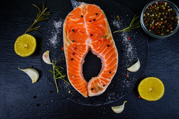 Wall Mural - Raw salmon steak and spices on a slate board. Top view