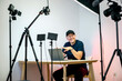 © eunikas - An influencer with a laptop creating content in his studio