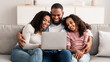 © Prostock-studio - Happy black family using laptop in living room
