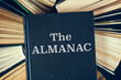Old hardcover books with book The Almanac on top.