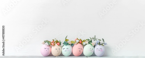 Obraz Dibond decorative easter eggs on a light wooden background. Easter-themed background with place for text