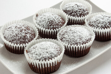 Several chocolate muffins on the white square plate