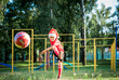 Emotional children play soccer in the summer in red uniforms. boy wearing santa claus hat