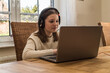 Young caucasian girl home schooling use headset to study something at online courses using notebook.
