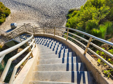 A Long Staircase Leading Down To A Sandy Beach Surrounded By Lush Green Trees  At West Street Beach In Laguna Beach California