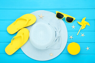 Canvas Print - Summer straw hat with sunglasses, flip flops, windmill and starfishes on blue wooden table