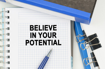 Among the documents, folders, a notebook with the inscription - BELIEVE IN YOUR POTENTIAL