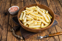 Frozen Crinkle Oven French Fries Potatoes Sticks In A Wooden Plate. Wooden Background. Top View