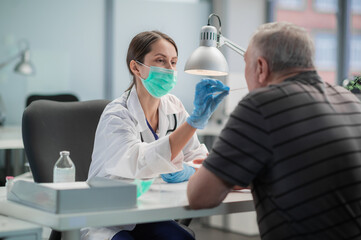 An adult man came to take a test for coronavirus by PCR, a young female laboratory assistant takes a smear.