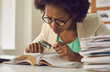 © Studio Romantic - Closeup portrait young african american woman analyst expert with magnifying glass searching information in document sitting at desk with paper folder stack in comfort office. Research work
