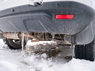 The rear bumper of the car with icicles.