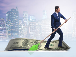 Wall Mural - Businessman rowing on dollar boat in business financial concept