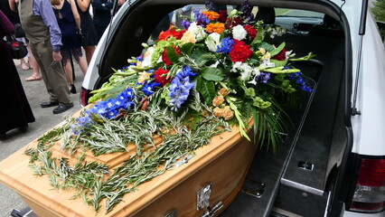 closeup shot of a funeral casket in a hearse or chapel or burial at cemetery
