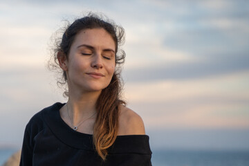 Caucasian girl with her eyes closed enjoying the sun and the sunset on the promenade in Palma de Mallorca, Spain (Perfect for copyspace)