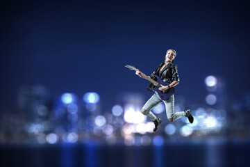 Wall Mural - Young and beautiful rock girl playing the electric guitar