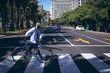 © Wavebreak Media - African american senior man wheeling bicycle across road on a pedestrian crossing