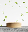 Wood product display podium. Falling green leaves on white background. 3d rendering