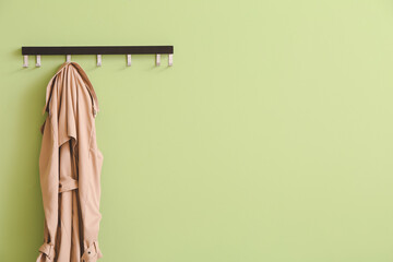 hanger with coat on color background