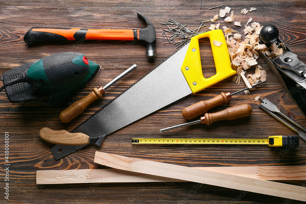 Set of carpenter's tools and saw dust on wooden background