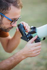 Wall Mural - amateur astronomer looking at the sky with a telescope.