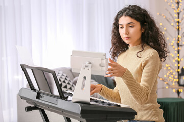 Young woman giving music lessons online at home