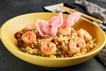 Canvas Print - Spicy Shrimp Fried Rice with Vegetables. Yellow plate with wooden chopstick on dark slate table. Chinese, asian, authentic food concept