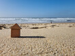 © Valeriia - Small miniature kids wooden toy home model on sunny sand beach with blue sky and white clouds and ocean background. Copy space of family lifestyle and business real estate property investment concept