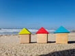 © Valeriia - Colourful blue yellow red miniature wooden kids toy home model on sunny sand beach with blue sky, ocean background. Copy space of family lifestyle and business real estate property investment concept